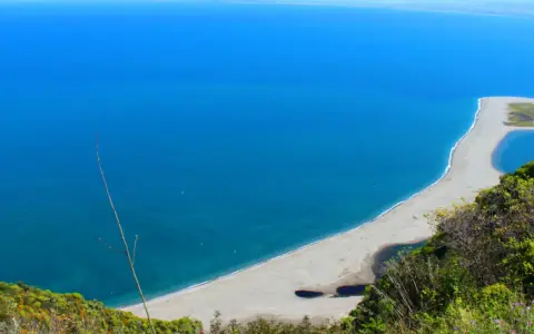 La **marinello spiaggia** si estende in un arco di sabbia chiara, lambita da un mare azzurro intenso. Laghi interni e vegetazione rigogliosa incorniciano questo angolo di paradiso.