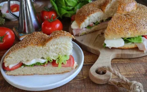 Un delizioso brioscione palermitano farcito con mozzarella, pomodoro e lattuga, pronto per essere gustato.