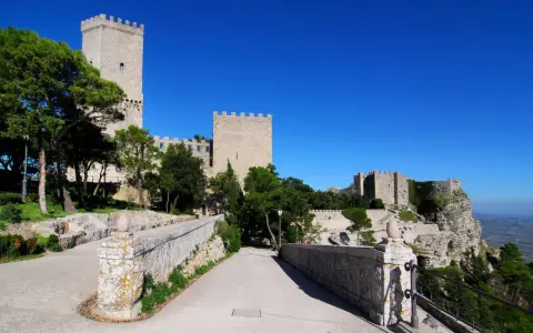 Erice: cosa vedere? Un antico castello domina il paesaggio, con torri imponenti e mura merlate che si stagliano contro il cielo azzurro.
