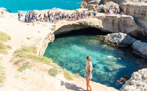 La Grotta della Poesia, con il suo mare cristallino, attira molti visitatori, ma il divieto di balneazione è ben visibile.