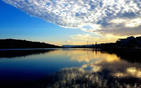 Tramonto sui Ganzirri, con cielo nuvoloso e riflessi dorati sull'acqua. Un luogo incantevole da esplorare.