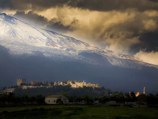 Villaggio ai piedi dell'Etna, vulcano imponente. L'etimologia del nome "Etna" evoca un fuoco eterno, come quello che arde sotto la neve.