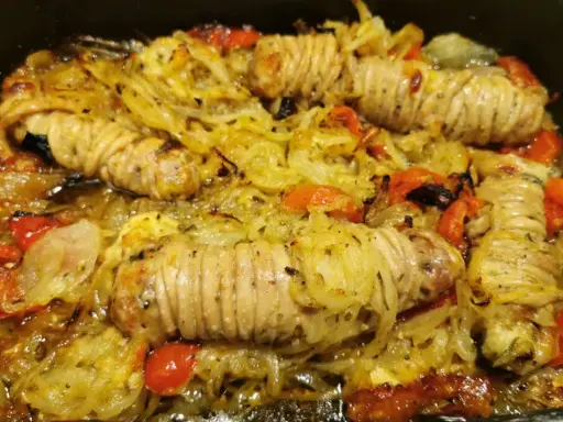 Stigghiole palermitane, un piatto saporito con interiora di agnello arrotolate e cotte al forno con cipolle e pomodorini.