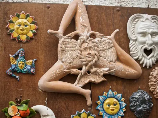 Ceramiche siciliane con la Trinacria, sole e maschere, simboli delle superstizioni siciliane.