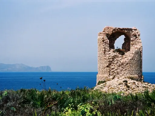 Torre saracena in rovina, un luogo suggestivo da scoprire a Terrasini, con il mare blu e le montagne sullo sfondo.