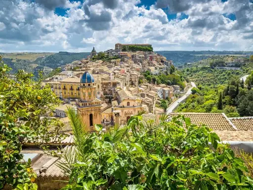 Panoramica di Ragusa Ibla, con la sua cupola blu e le case arroccate, un vero significato di bellezza barocca siciliana.