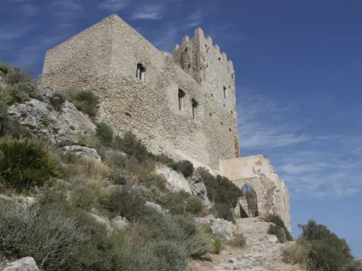 Antica fortezza, la Madonna del Castello di Palma di Montechiaro, si erge su un colle roccioso sotto un cielo azzurro.