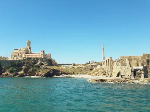 Antica tonnara di Portopalo con il castello sulla scogliera e le rovine di un'antica struttura industriale.
