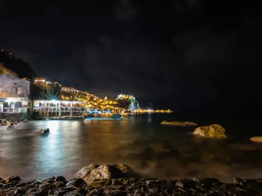 Scilla di notte: luci, castello e mare calmo. Perfetto per scoprire cosa fare a Scilla la sera, tra ristoranti sul mare e borghi illuminati.