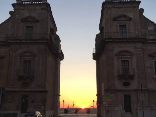 Tramonto tra i due palazzi che incorniciano la porta del sole a Palermo.