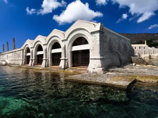 Antica tonnara, un tempo fiorente grazie a Ignazio Florio Senior, con archi imponenti sul mare cristallino.