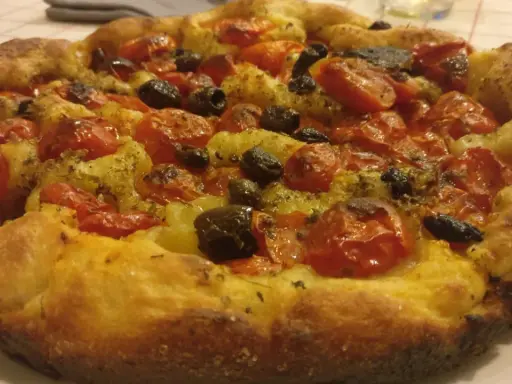 Focaccia con pomodorini e olive, un tripudio di specialità pugliesi salate. Croccante fuori, morbida dentro, profumata di erbe aromatiche.