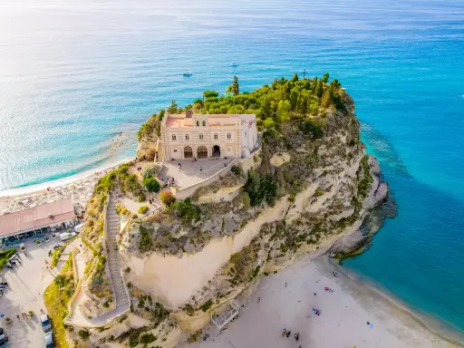 Santuario di Santa Maria dell'Isola a picco sul mare turchese, un must per chi cerca cosa fare a Tropea. Spiaggia e panorama mozzafiato.