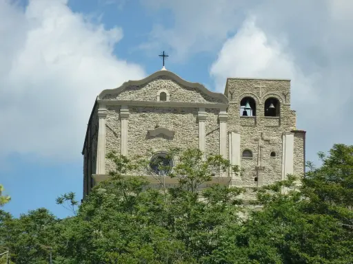 Chiesa Madre di Corleone, un gioiello di pietra con campanile e campane, tra il verde degli alberi. Un luogo da scoprire tra le cose da vedere a Corleone.