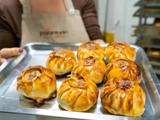 Una teglia piena di fragranti pastieri modicani appena sfornati, pronti per essere gustati.