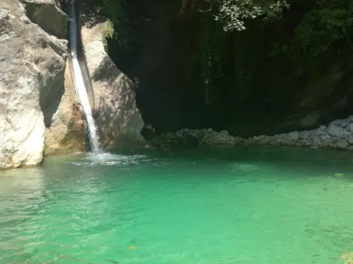 Cascata che si getta nella **pozza della Madonna**, un'oasi di acqua cristallina tra rocce e vegetazione rigogliosa.