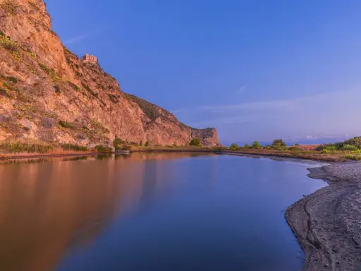 Laghetto di Marinello con la rocca e la leggenda della Madonna. Riflessi dorati e blu intenso.