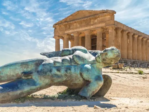 Statua di Icaro caduto nella Valle dei Templi, Agrigento. Il tempio dorico sullo sfondo è il Tempio della Concordia.