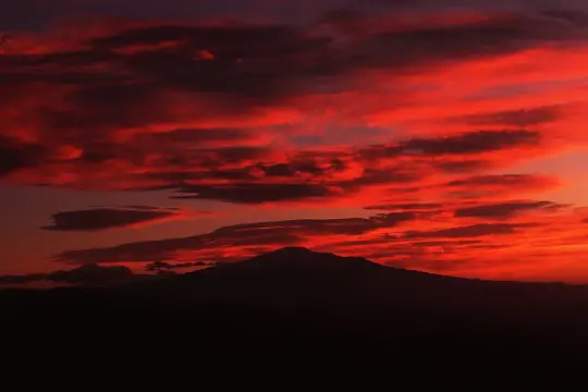 Tramonto infuocato sull'Etna, un vulcano maestoso che domina il paesaggio. Etna iddu, un'icona siciliana.