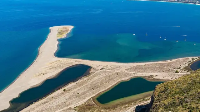 La Madonna di Tindari veglia sulla spiaggia, con le sue acque turchesi e la sabbia dorata che si estendono verso il mare.
