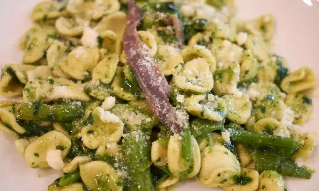 Orecchiette con cime di rapa, uno dei piatti tipici pugliesi primi, condite con acciughe e formaggio grattugiato.