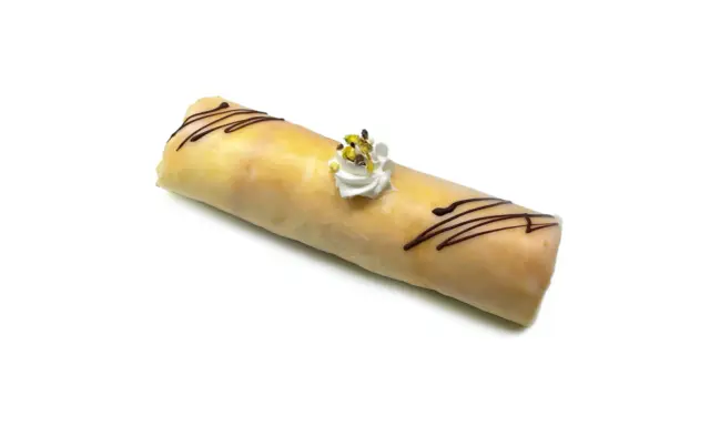 Dolce rotolo glassato con cioccolato e panna, un delizioso dito d'apostolo pronto da gustare.