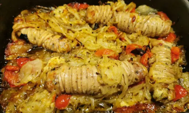 Stigghiole palermitane, un piatto saporito con interiora di agnello arrotolate e cotte al forno con cipolle e pomodorini.