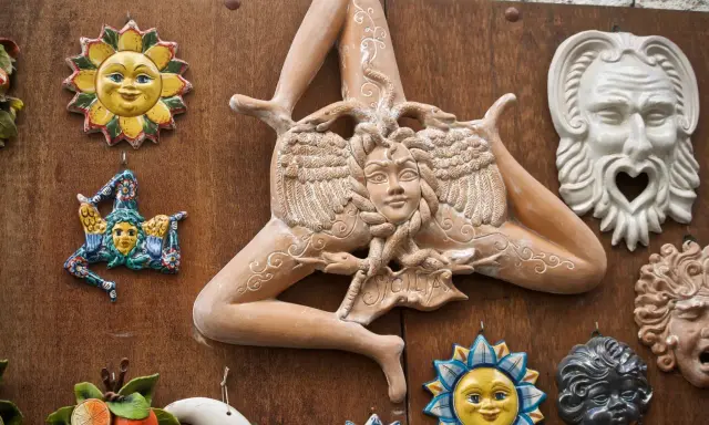 Ceramiche siciliane con la Trinacria, sole e maschere, simboli delle superstizioni siciliane.