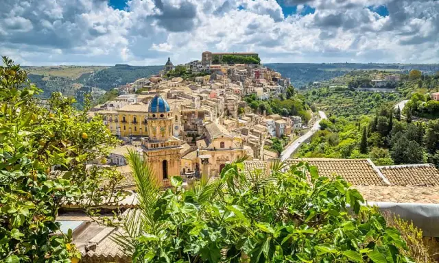 Panoramica di Ragusa Ibla, con la sua cupola blu e le case arroccate, un vero significato di bellezza barocca siciliana.