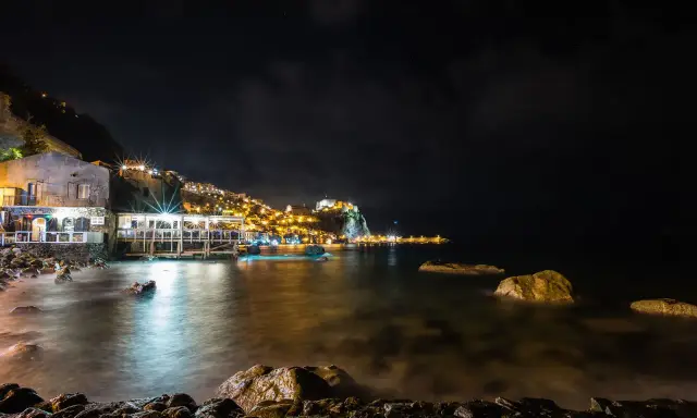 Scilla di notte: luci, castello e mare calmo. Perfetto per scoprire cosa fare a Scilla la sera, tra ristoranti sul mare e borghi illuminati.