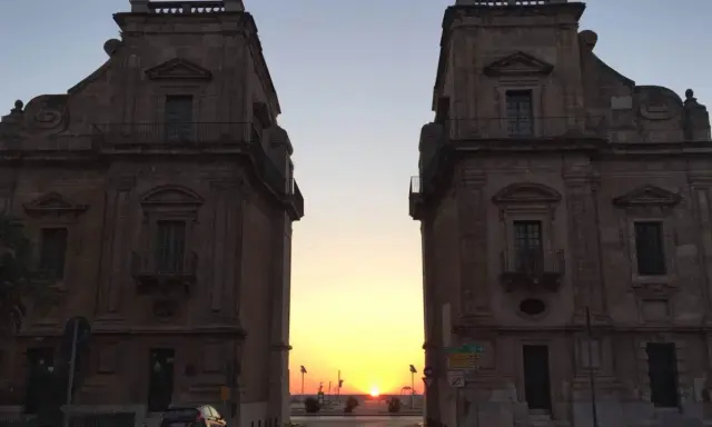 Tramonto tra i due palazzi che incorniciano la porta del sole a Palermo.