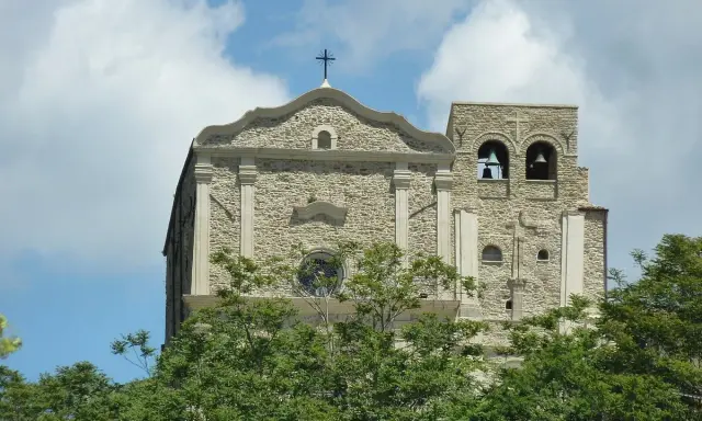 Chiesa Madre di Corleone, un gioiello di pietra con campanile e campane, tra il verde degli alberi. Un luogo da scoprire tra le cose da vedere a Corleone.