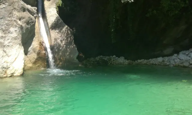Cascata che si getta nella **pozza della Madonna**, un'oasi di acqua cristallina tra rocce e vegetazione rigogliosa.