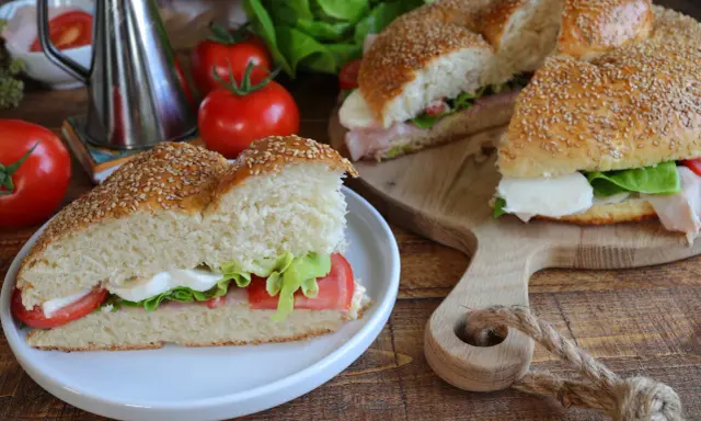 Un delizioso brioscione palermitano farcito con mozzarella, pomodoro e lattuga, pronto per essere gustato.