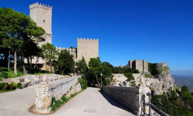 Erice: cosa vedere? Un antico castello domina il paesaggio, con torri imponenti e mura merlate che si stagliano contro il cielo azzurro.