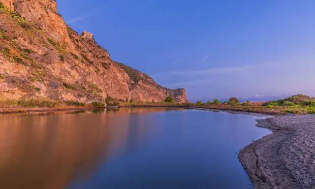Laghetto di Marinello con la rocca e la leggenda della Madonna. Riflessi dorati e blu intenso.