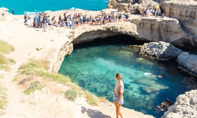La Grotta della Poesia, con il suo mare cristallino, attira molti visitatori, ma il divieto di balneazione è ben visibile.