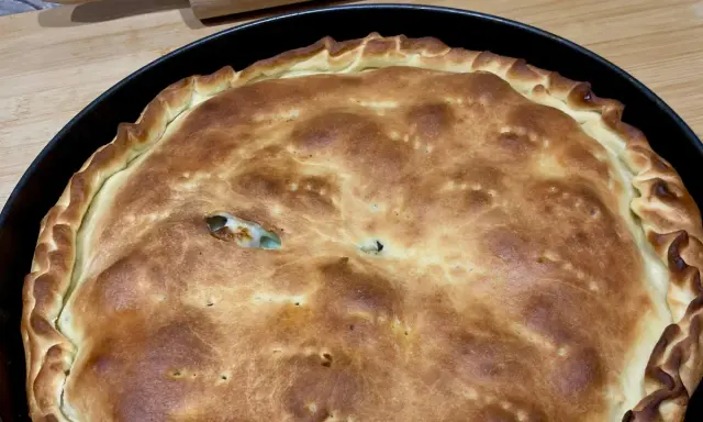 Schiacciatella pane dorata e fragrante, appena sfornata in teglia, con un ripieno invitante che fa capolino da una fessura.