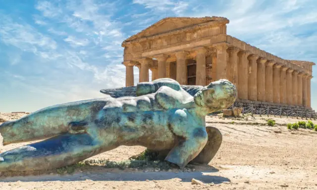 Statua di Icaro caduto nella Valle dei Templi, Agrigento. Il tempio dorico sullo sfondo è il Tempio della Concordia.