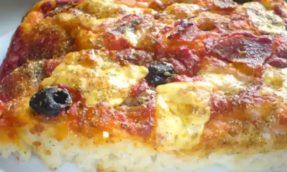 Una fetta di pizza muddiata, con pomodoro, formaggio filante, salame e olive nere, condita con erbe aromatiche.