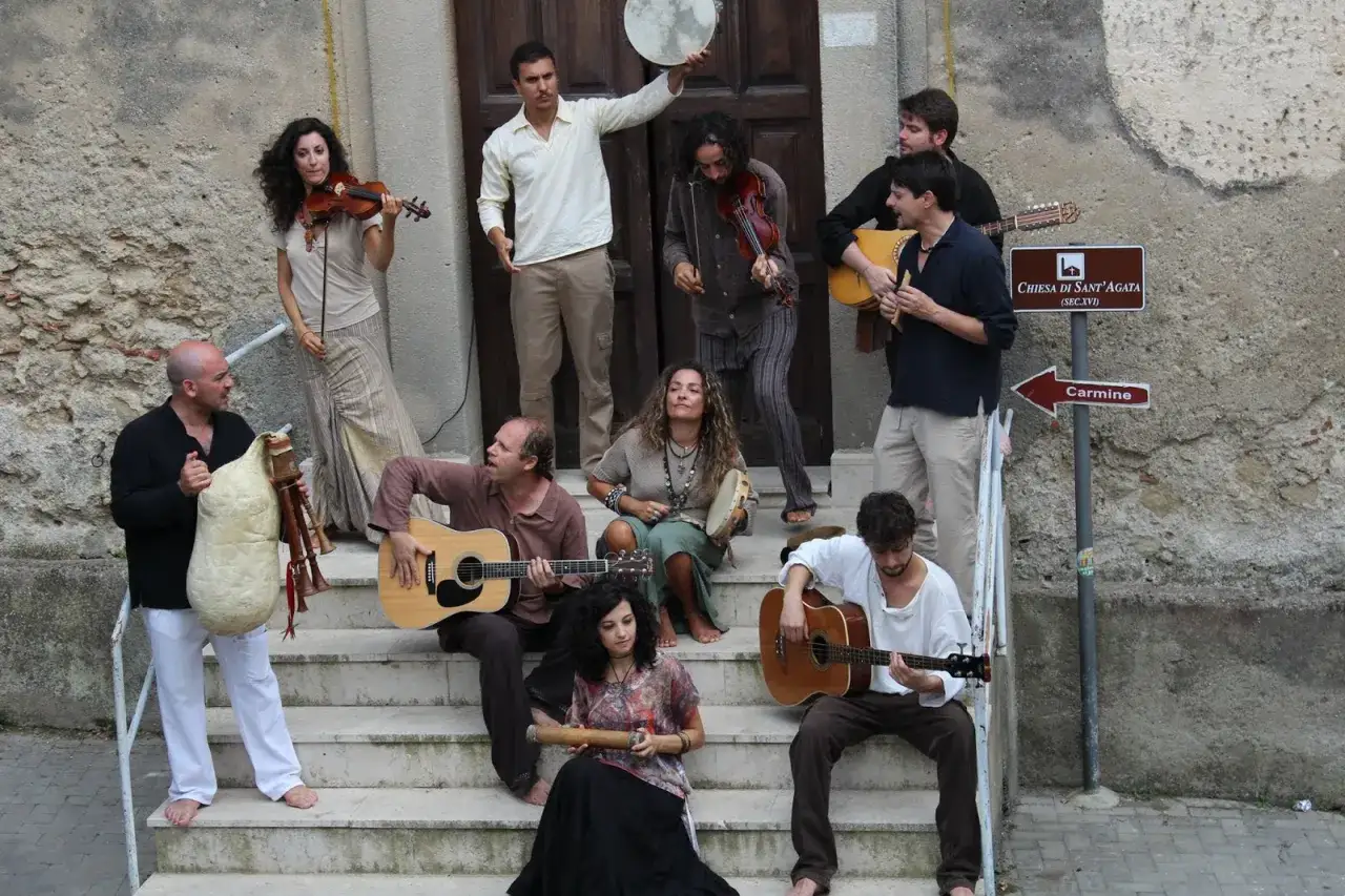 Un gruppo di musicisti suona strumenti tradizionali, evocando le melodie delle canzoni siciliane famose.
