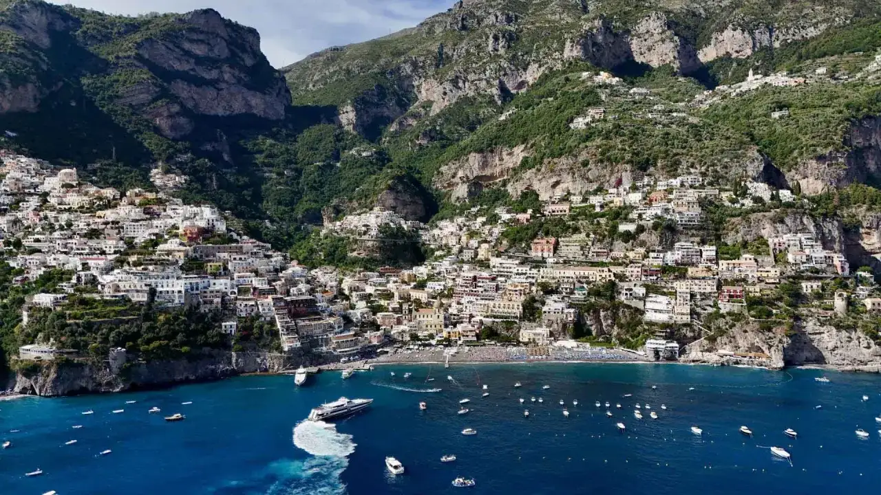 Vista mozzafiato dal punto panoramico di Positano, con le case colorate aggrappate alla scogliera e il mare blu intenso.