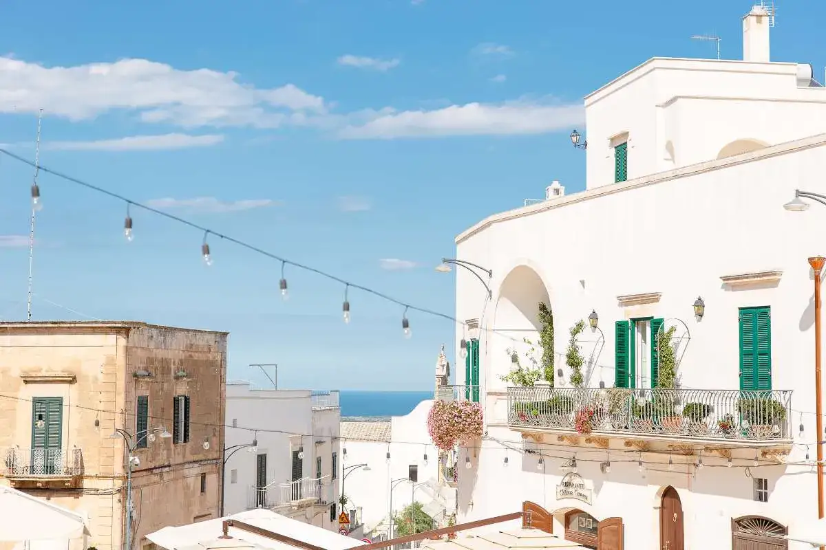 Scopri cosa vedere a Ostuni in mezza giornata: scorci bianchi, balconi fioriti e il mare all'orizzonte.