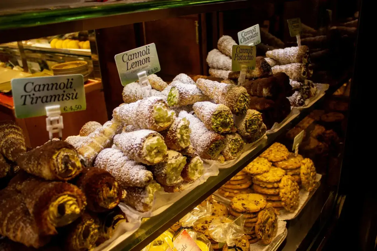 Cannoli al limone, tiramisù, pistacchio e cioccolato, specialità siciliane in vetrina, invitano a un assaggio di dolcezza.