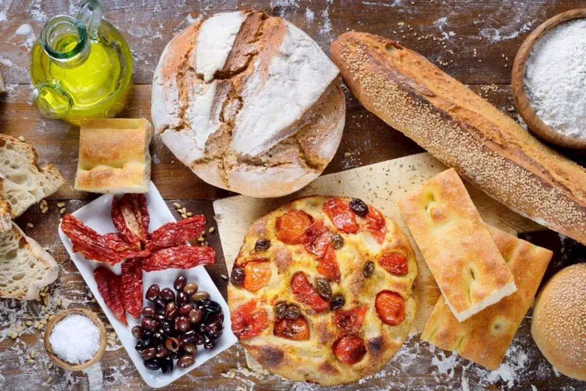 Pane, focaccia, pomodori secchi e olive: un assaggio della puglia cucina. Olio d'oliva e sale completano questa tavola rustica.