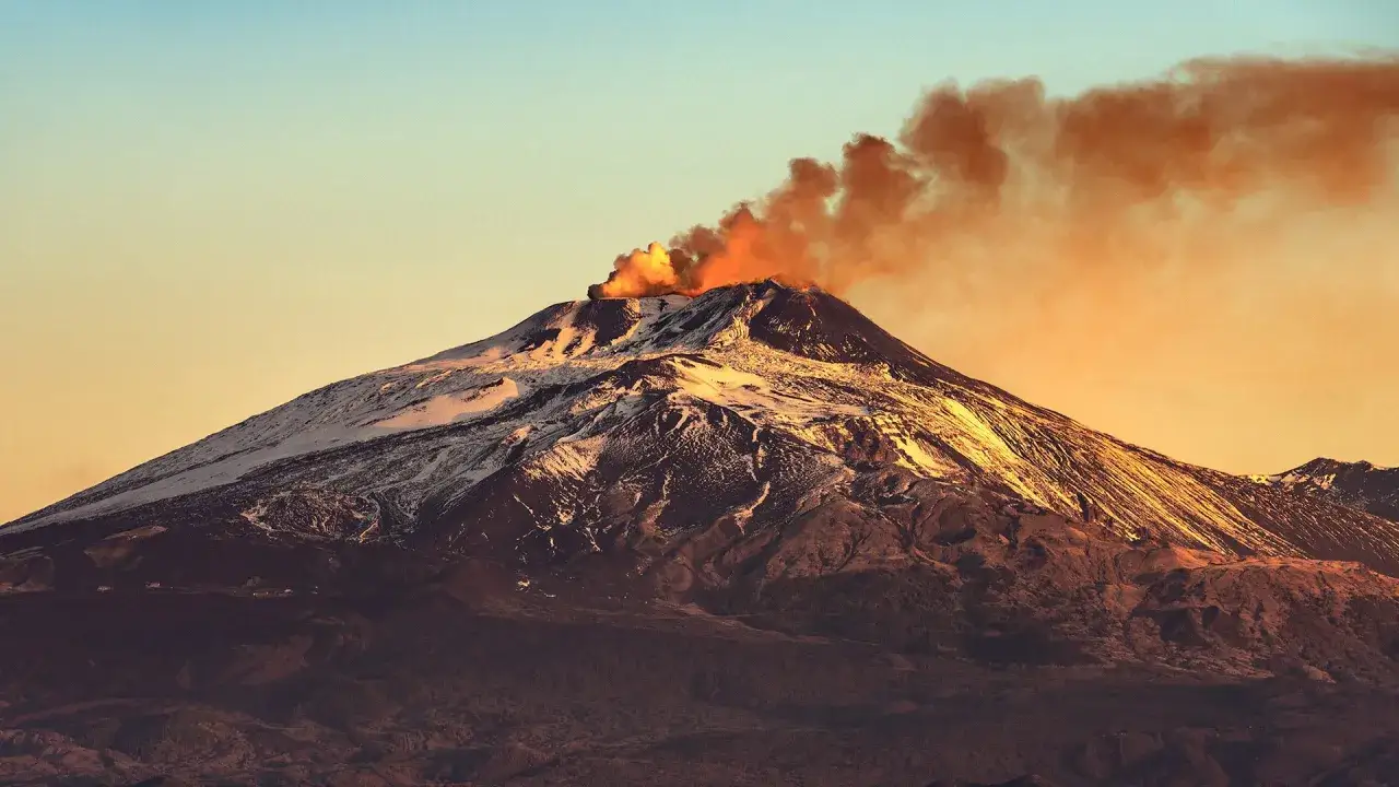 Etna fumante al tramonto, un gigante che evoca l'etimologia del suo nome, forse da