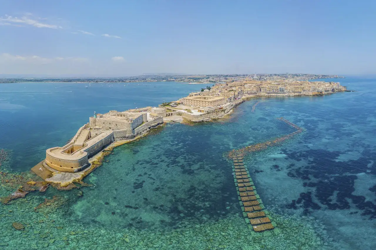 Fortificazioni di Siracusa, un luogo dove l'etimologia si fonde con la storia, con il castello a picco sul mare cristallino.