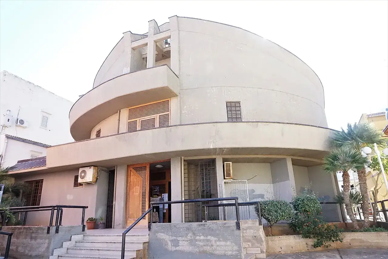 Edificio moderno con elementi curvi, che ricorda la Madonna del Soccorso a Castellammare del Golfo.