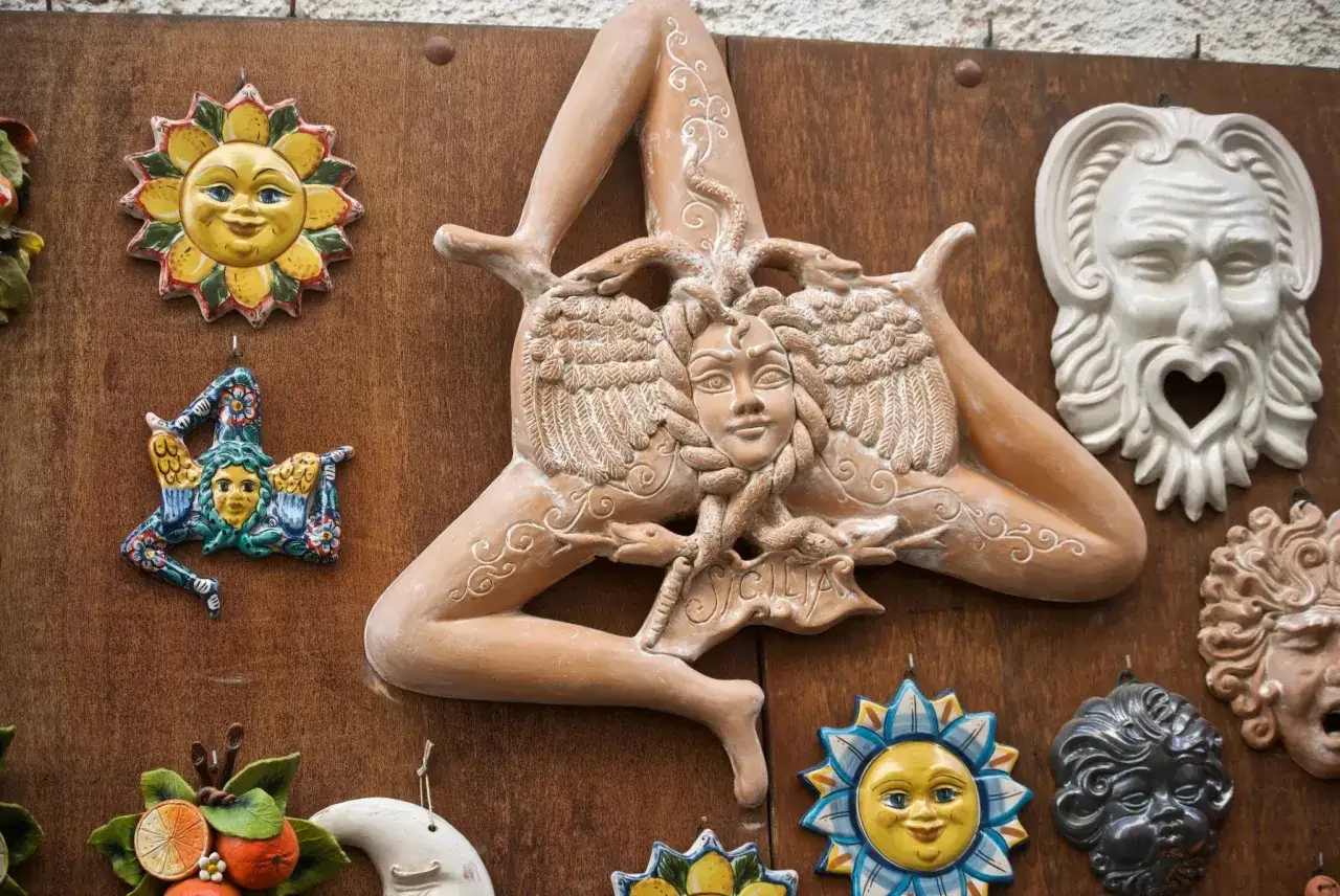 Ceramiche siciliane: la Trinacria, soli sorridenti e maschere, simboli di antiche superstizioni siciliane.