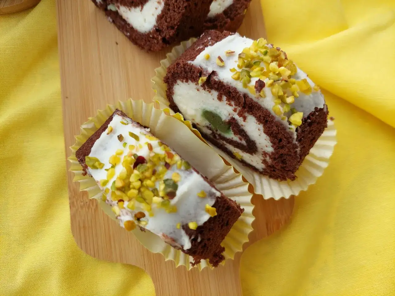 Deliziosi rotoli di cioccolato con crema bianca e pistacchi, un vero rollò nisseno pronto da gustare.